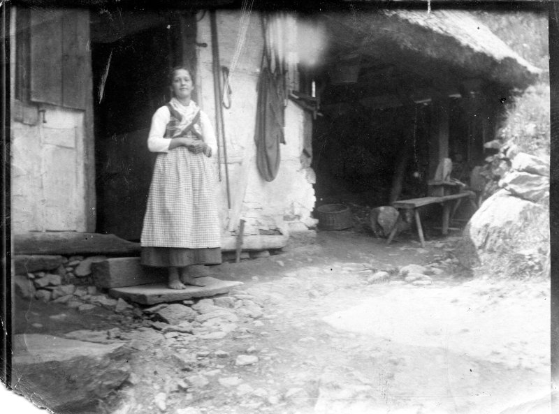 Barfuß am strohgedeckten Haus, wohl um 1900