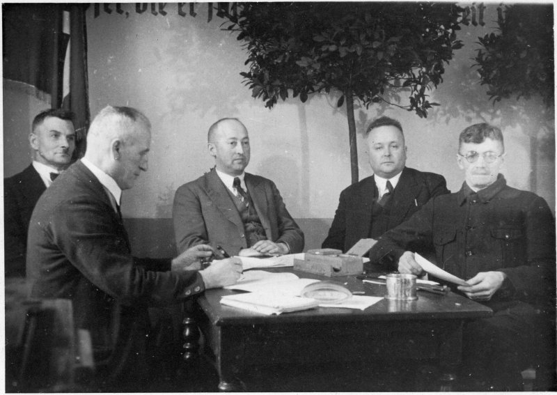 Ernste Herrenrunde am Tisch, 1920-30er