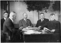 Ernste Herrenrunde am Tisch, 1920-30er
