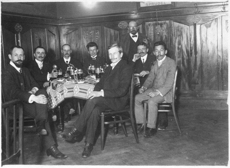 Acht Herren am Kneipenecktisch, wohl um 1910